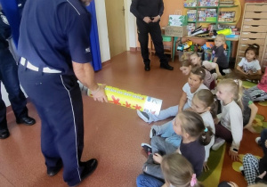Przedszkolaki i uczniowie SP 13 wykonują zdjęcie pamiątkowe z przedstawicielami policji i straży miejskiej.