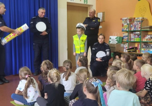 Policjanci rozmawiają z dziećmi o bezpieczeństwie na drodze.