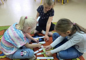 Przedszkolaki układają puzzle.