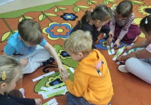 Przedszkolaki układają puzzle.