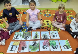 Dzieci prezentują ułożony napis"Dzień Drzewa".