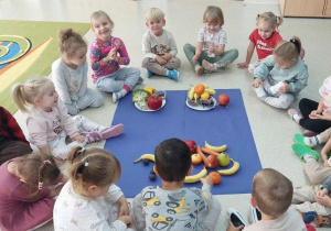 Dzieci prezentują posegregowane warzywa i owoce.