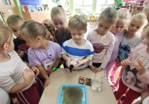 Chłopiec wlewa mydło do wody i pieprzu.