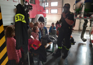 Strażak pokazuje dzieciom maskę.