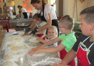Dzieci przygotowują ciasto na pizzę