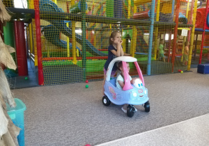 Dzieci jeżdżą autkiem.