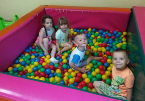 Dzieci bawią się w basenie z piłeczkami.