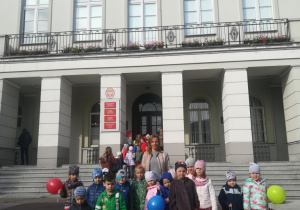 Dzieci z grupy Żabki stoją na schodach przed Urzędem Miasta