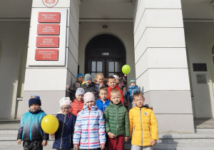 Dzieci z grupy Motylki stoją na schodach przed Urzędem Miasta
