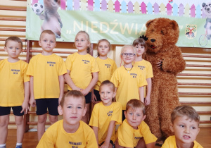 dzieci stoją z Niedźwiadkiem