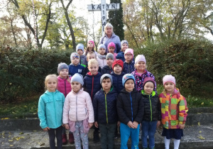 Dzieci stoją pod pomnikiem pomordowanych w Katyniu