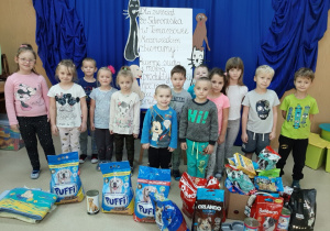 Dzieci prezentują produkty zebrane dla zwierząt.
