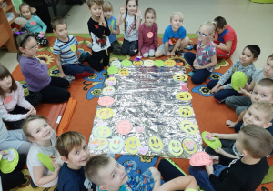 dzieci układają obrazek z pokolorowanych buziek