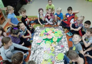 dzieci układają obrazek z pokolorowanych buziek