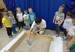 dzieci szukają w piasku skarbów