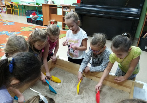 dzieci szukają w piasku skarbów